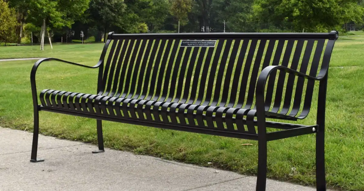 Black personalized metal bench on a park pathway